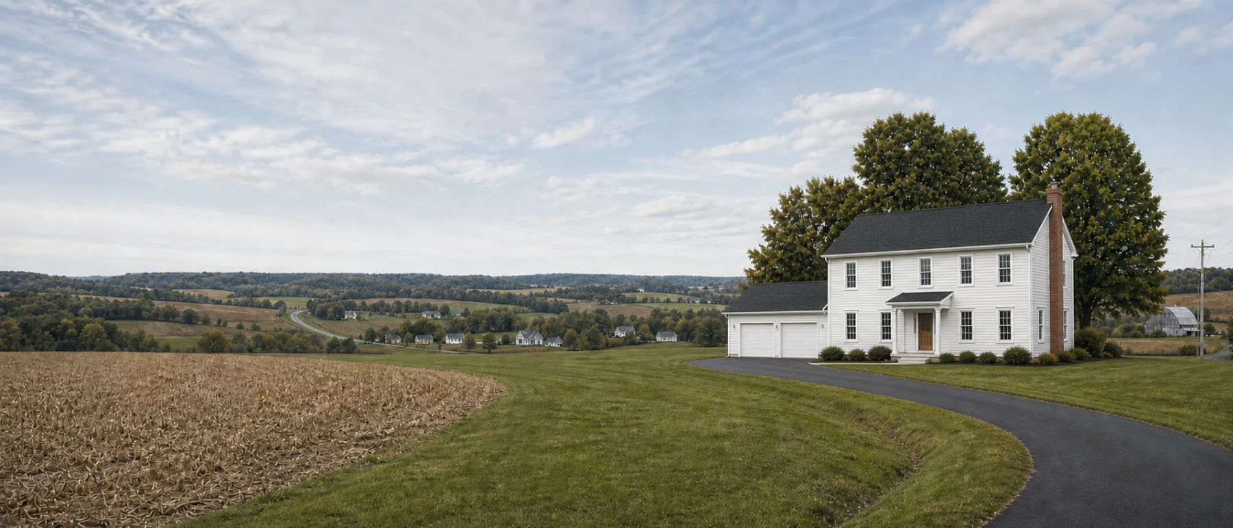 A two-story home with a dark shingled roof and light gray siding on open farmland.